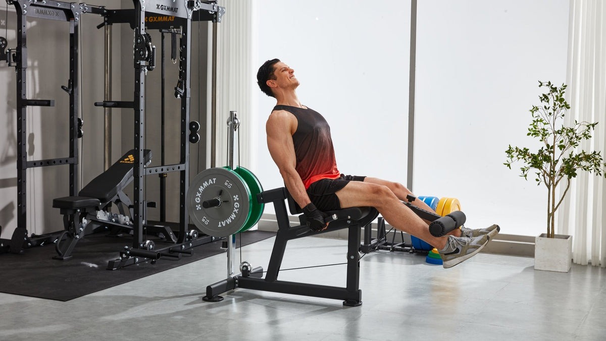Man training on the GXMMAT leg extension and curl machine in a home gym