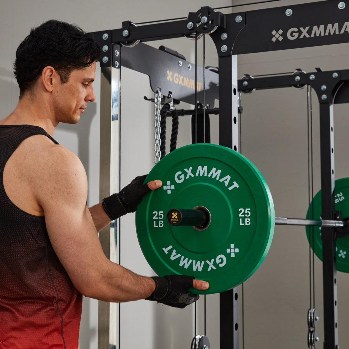 Lifter loading a 25 lb GXMMAT bumper plate onto an Olympic barbell