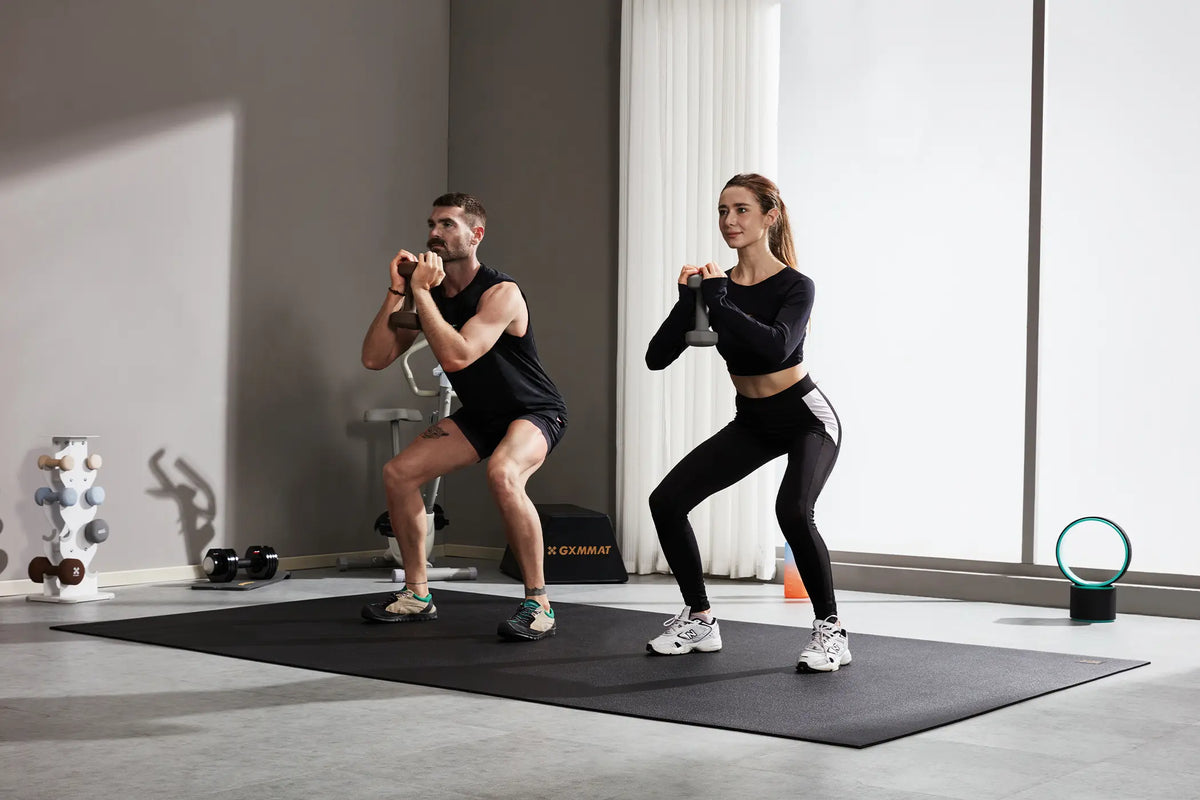 Two people doing a quiet dumbbell workout on a GXMMAT large exercise mat